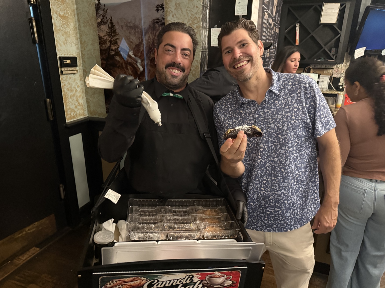 Philip DiMaria serving a freshly filled cannoli from his mobile cart
